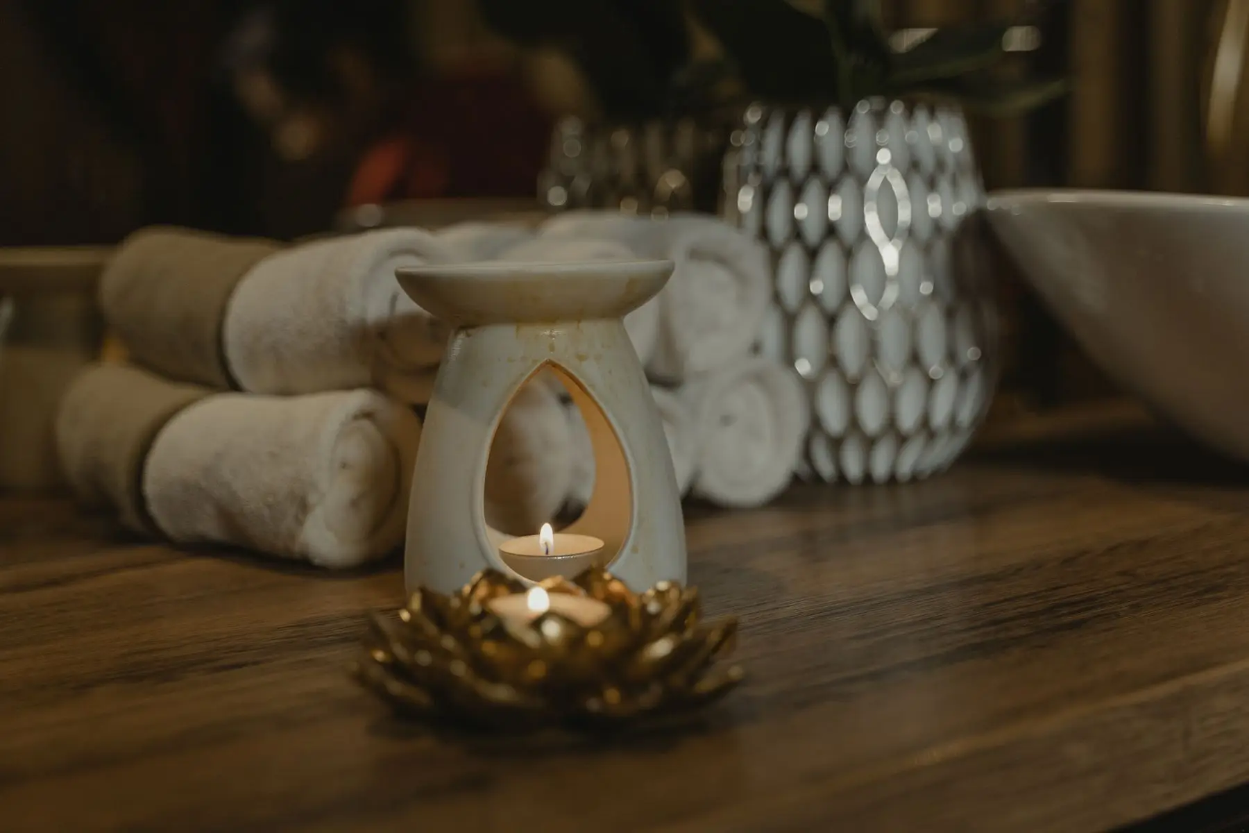 Sample image: rolled towels beside a softly lit oil warmer
