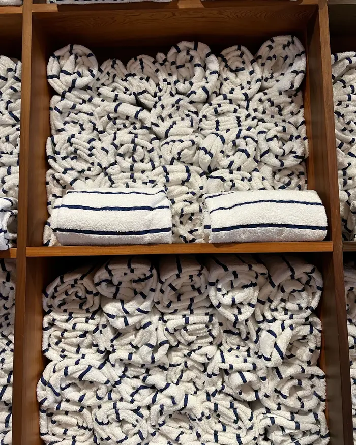 Sample image: shelves of rolled white towels and smooth stones