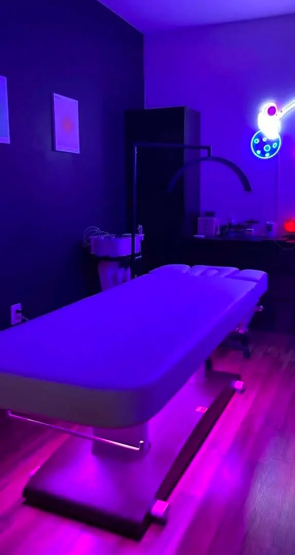 The massage table at Bliss Haven, under low violet lighting
