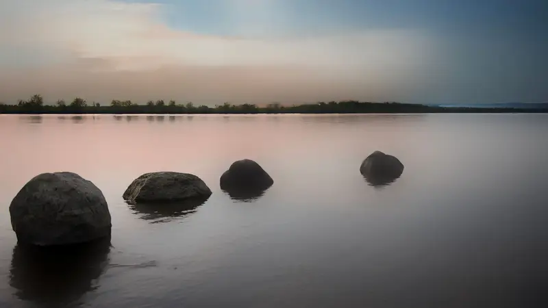 Sample image: smooth stones resting in still water at dusk